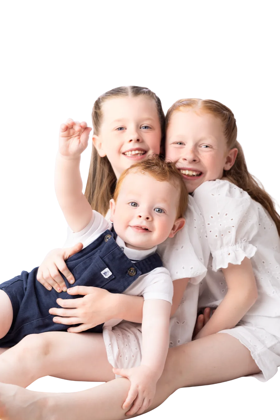 Three young children smiling and hugging